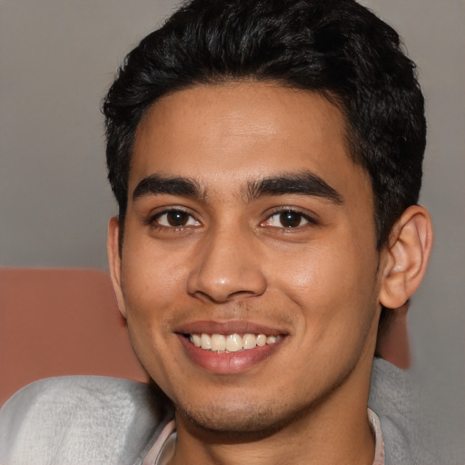 Joyful latino young-adult male with short  black hair and brown eyes
