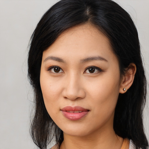 Joyful asian young-adult female with long  black hair and brown eyes