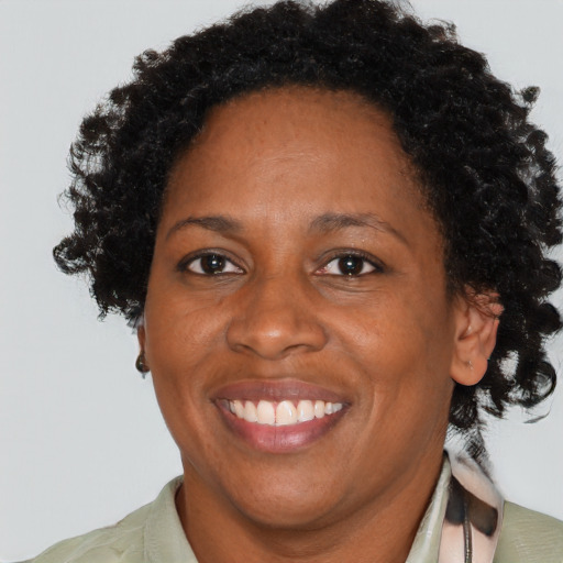 Joyful black adult female with short  brown hair and brown eyes