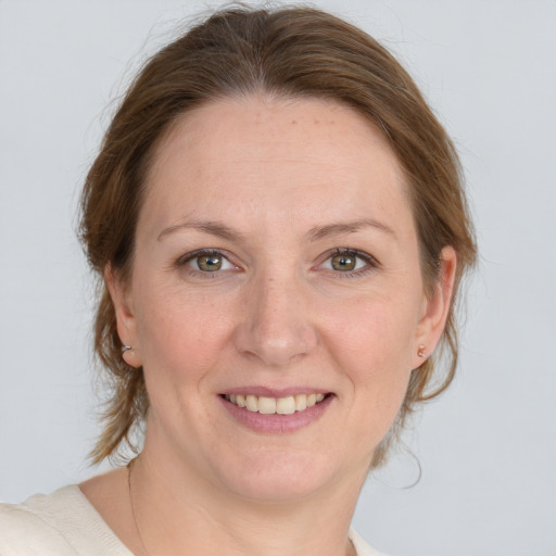 Joyful white adult female with medium  brown hair and grey eyes