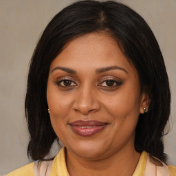 Joyful black adult female with medium  brown hair and brown eyes