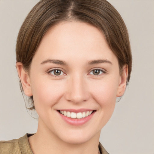 Joyful white young-adult female with short  brown hair and grey eyes