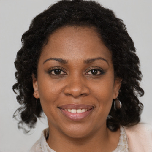 Joyful black adult female with medium  brown hair and brown eyes