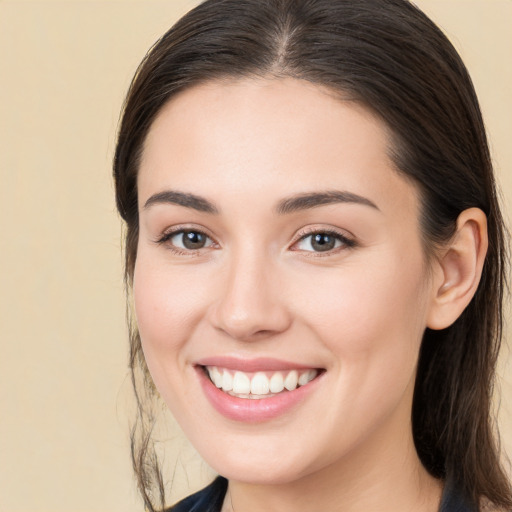 Joyful white young-adult female with long  brown hair and brown eyes