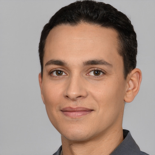 Joyful white young-adult male with short  black hair and brown eyes