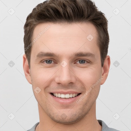 Joyful white young-adult male with short  brown hair and grey eyes