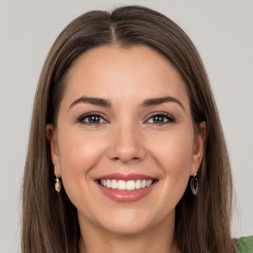 Joyful white young-adult female with long  brown hair and grey eyes