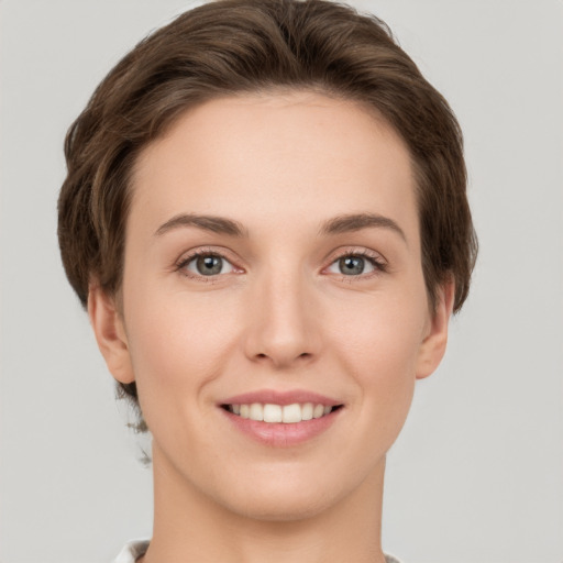 Joyful white young-adult female with short  brown hair and grey eyes