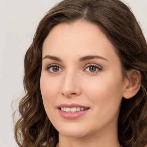 Joyful white young-adult female with long  brown hair and green eyes