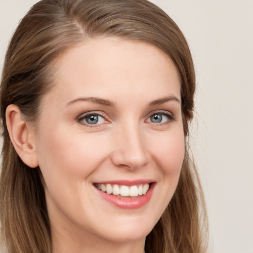 Joyful white young-adult female with long  brown hair and grey eyes