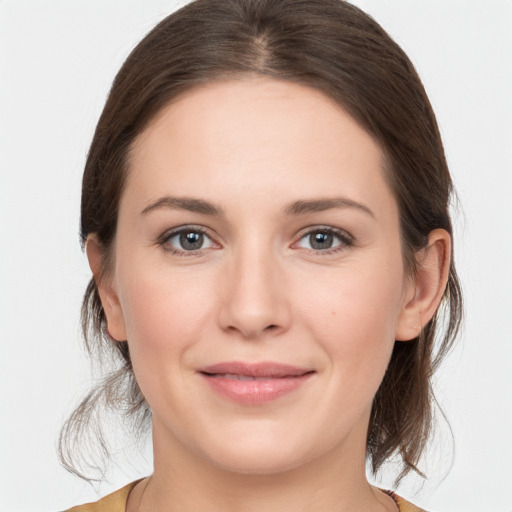 Joyful white young-adult female with medium  brown hair and grey eyes