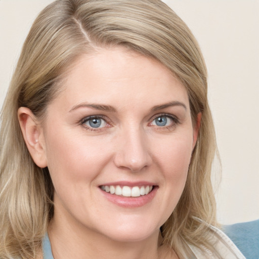 Joyful white young-adult female with medium  brown hair and blue eyes