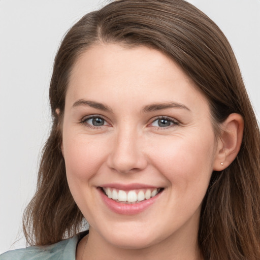 Joyful white young-adult female with long  brown hair and grey eyes