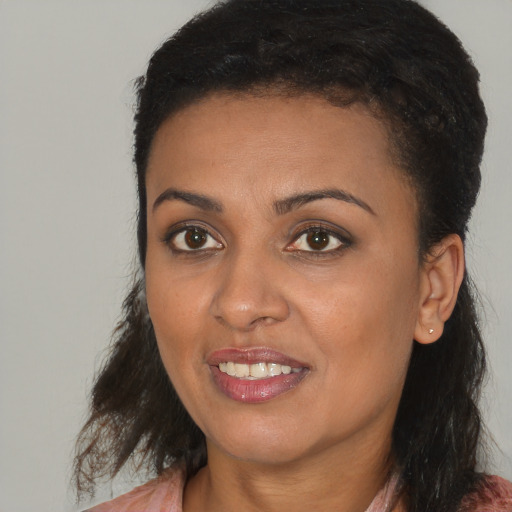 Joyful black young-adult female with medium  brown hair and brown eyes