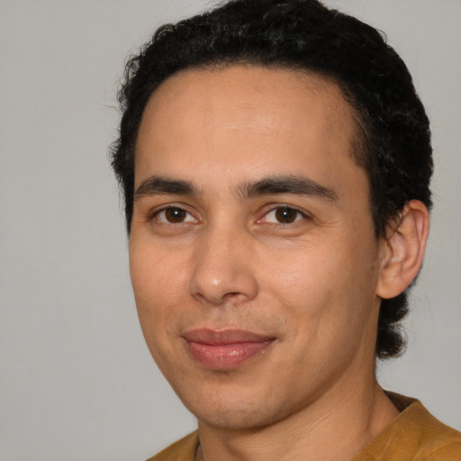Joyful latino young-adult male with short  brown hair and brown eyes