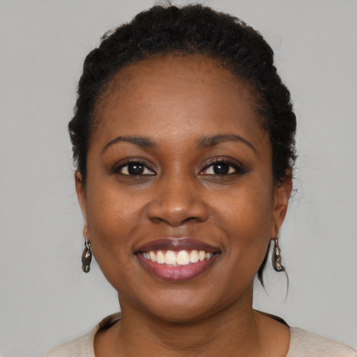 Joyful black young-adult female with short  brown hair and brown eyes