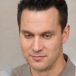 Joyful white adult male with short  brown hair and brown eyes