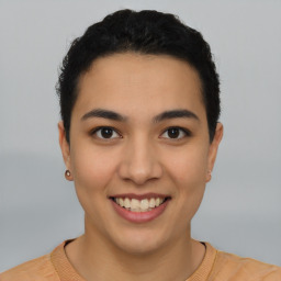 Joyful latino young-adult female with short  black hair and brown eyes