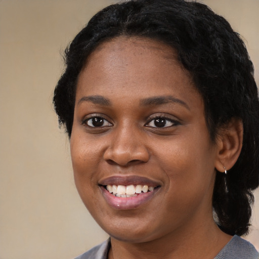 Joyful black young-adult female with medium  black hair and brown eyes