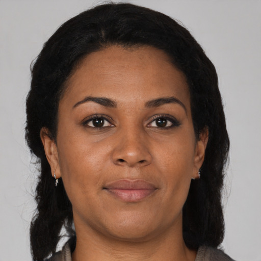 Joyful black adult female with medium  brown hair and brown eyes
