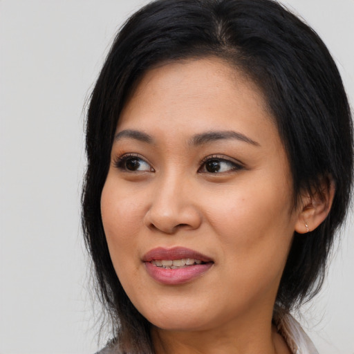 Joyful latino young-adult female with medium  black hair and brown eyes