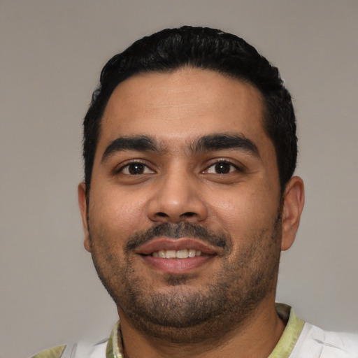 Joyful latino young-adult male with short  black hair and brown eyes