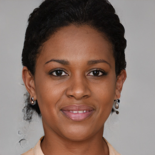 Joyful black young-adult female with short  brown hair and brown eyes