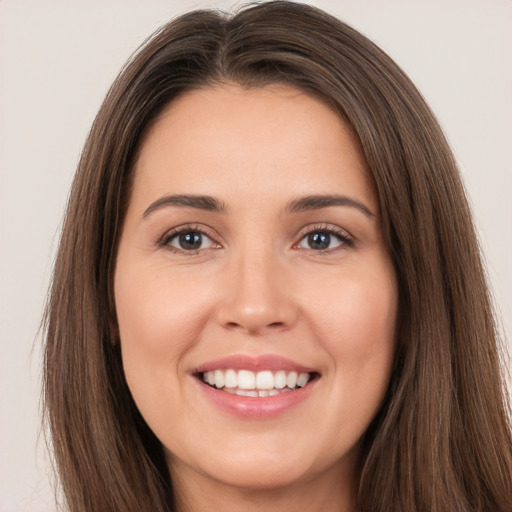 Joyful white young-adult female with long  brown hair and brown eyes