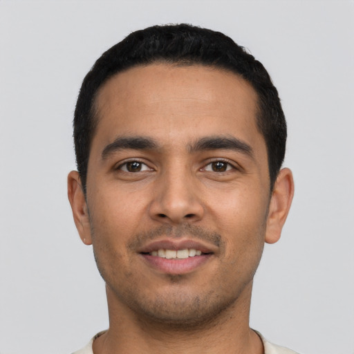 Joyful latino young-adult male with short  black hair and brown eyes