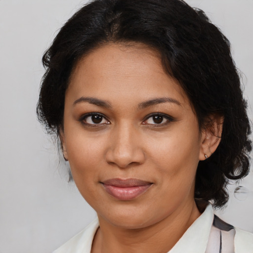 Joyful latino adult female with medium  brown hair and brown eyes