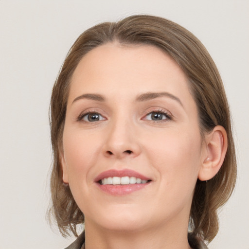 Joyful white young-adult female with medium  brown hair and grey eyes