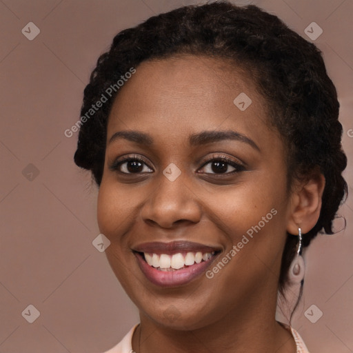 Joyful black young-adult female with long  brown hair and brown eyes