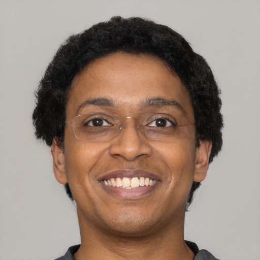 Joyful black adult male with short  brown hair and brown eyes