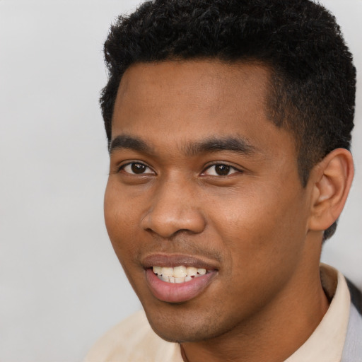 Joyful black young-adult male with short  black hair and brown eyes
