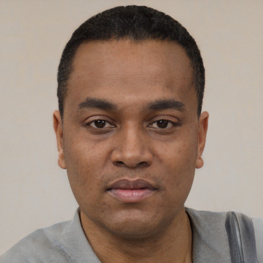 Joyful black young-adult male with short  black hair and brown eyes
