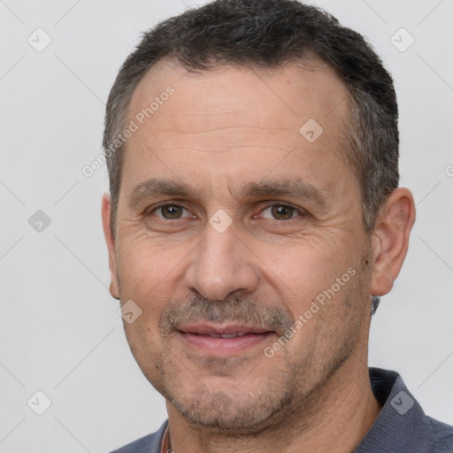 Joyful white adult male with short  brown hair and brown eyes