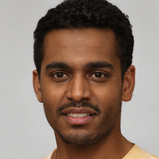 Joyful black young-adult male with short  black hair and brown eyes