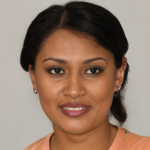Joyful black young-adult female with medium  brown hair and brown eyes