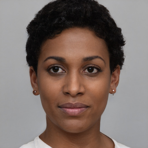 Joyful black young-adult female with short  black hair and brown eyes