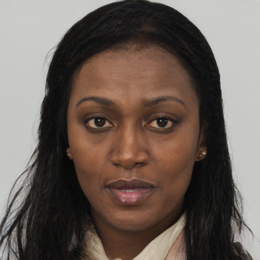 Joyful black young-adult female with long  brown hair and brown eyes