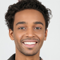 Joyful black young-adult male with short  black hair and brown eyes