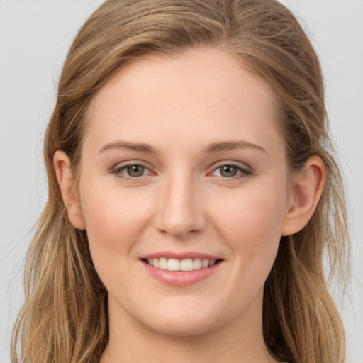 Joyful white young-adult female with long  brown hair and grey eyes