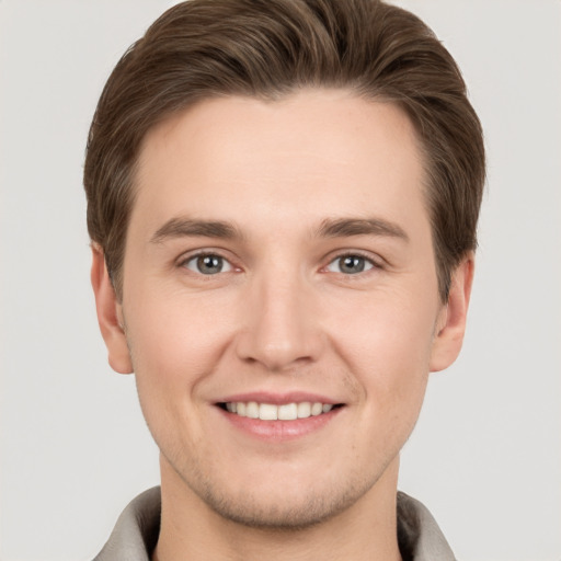 Joyful white young-adult male with short  brown hair and grey eyes