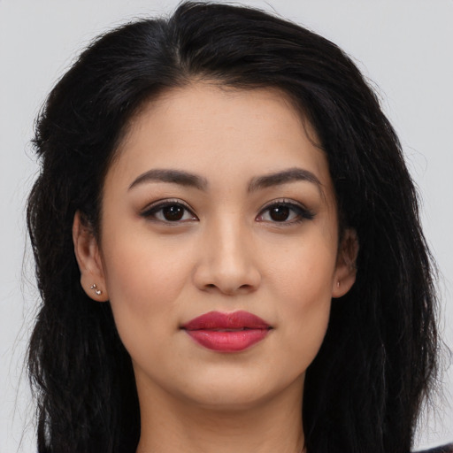 Joyful latino young-adult female with long  black hair and brown eyes