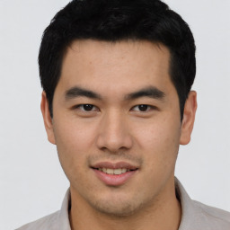 Joyful asian young-adult male with short  black hair and brown eyes