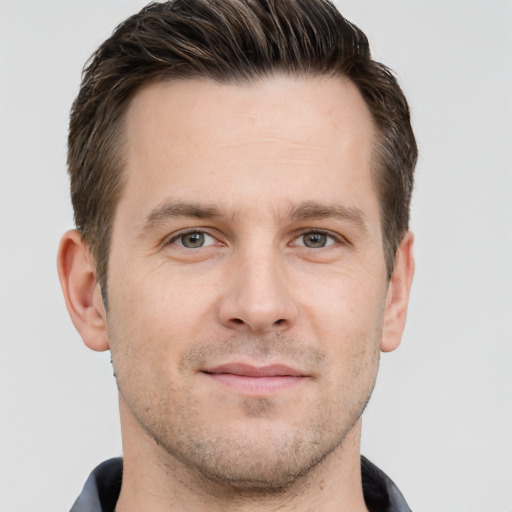 Joyful white young-adult male with short  brown hair and grey eyes