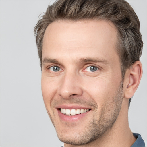 Joyful white adult male with short  brown hair and grey eyes