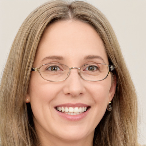 Joyful white adult female with long  brown hair and green eyes