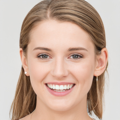 Joyful white young-adult female with medium  brown hair and green eyes