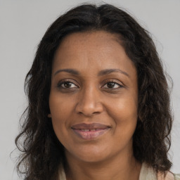 Joyful black adult female with long  brown hair and brown eyes